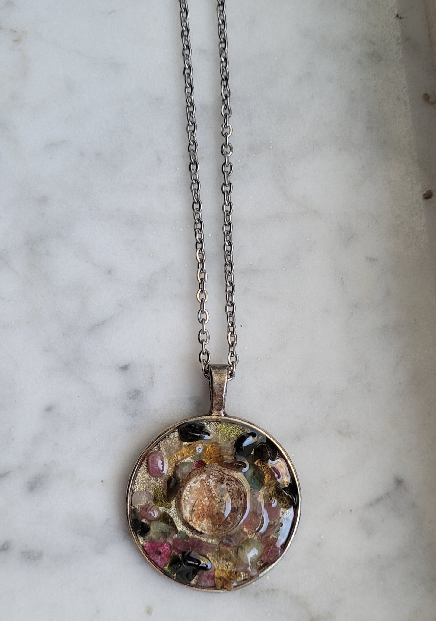 Necklace with a round pendant on a marble surface
