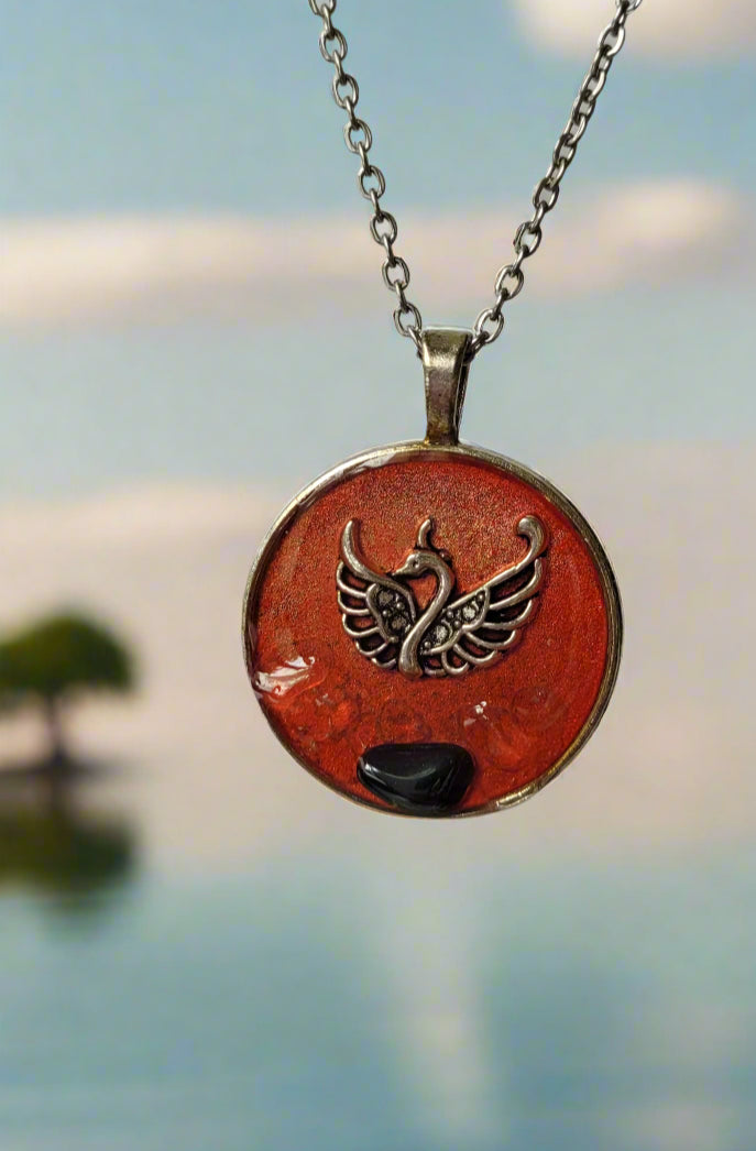 Necklace with a round pendant featuring a phoenix design on a plain background