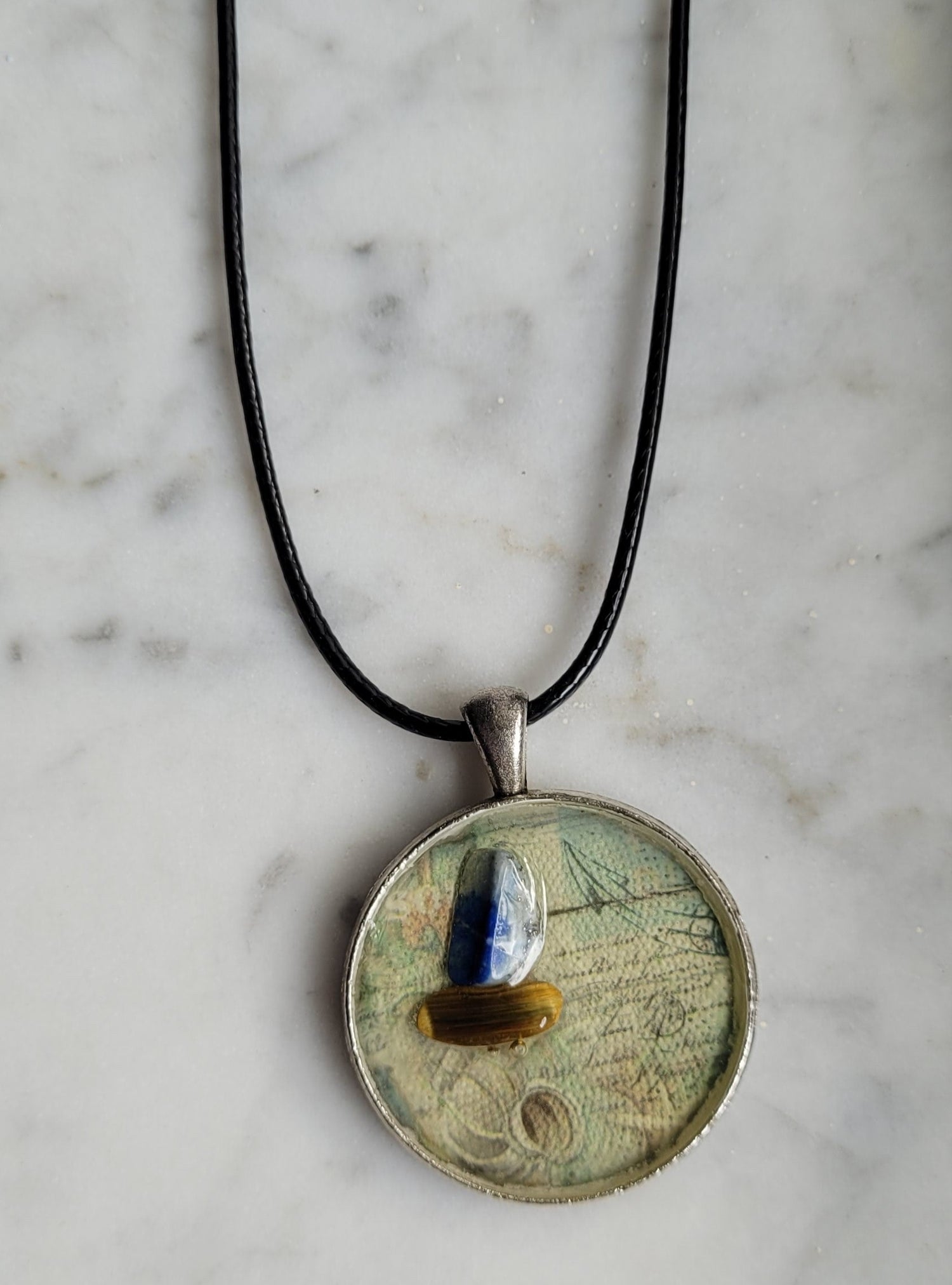 Necklace with a round pendant on a marble surface