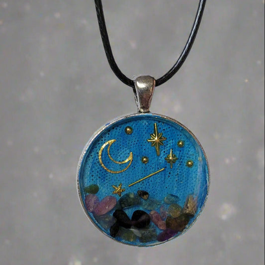 Necklace with a round pendant featuring celestial design on a white surface.