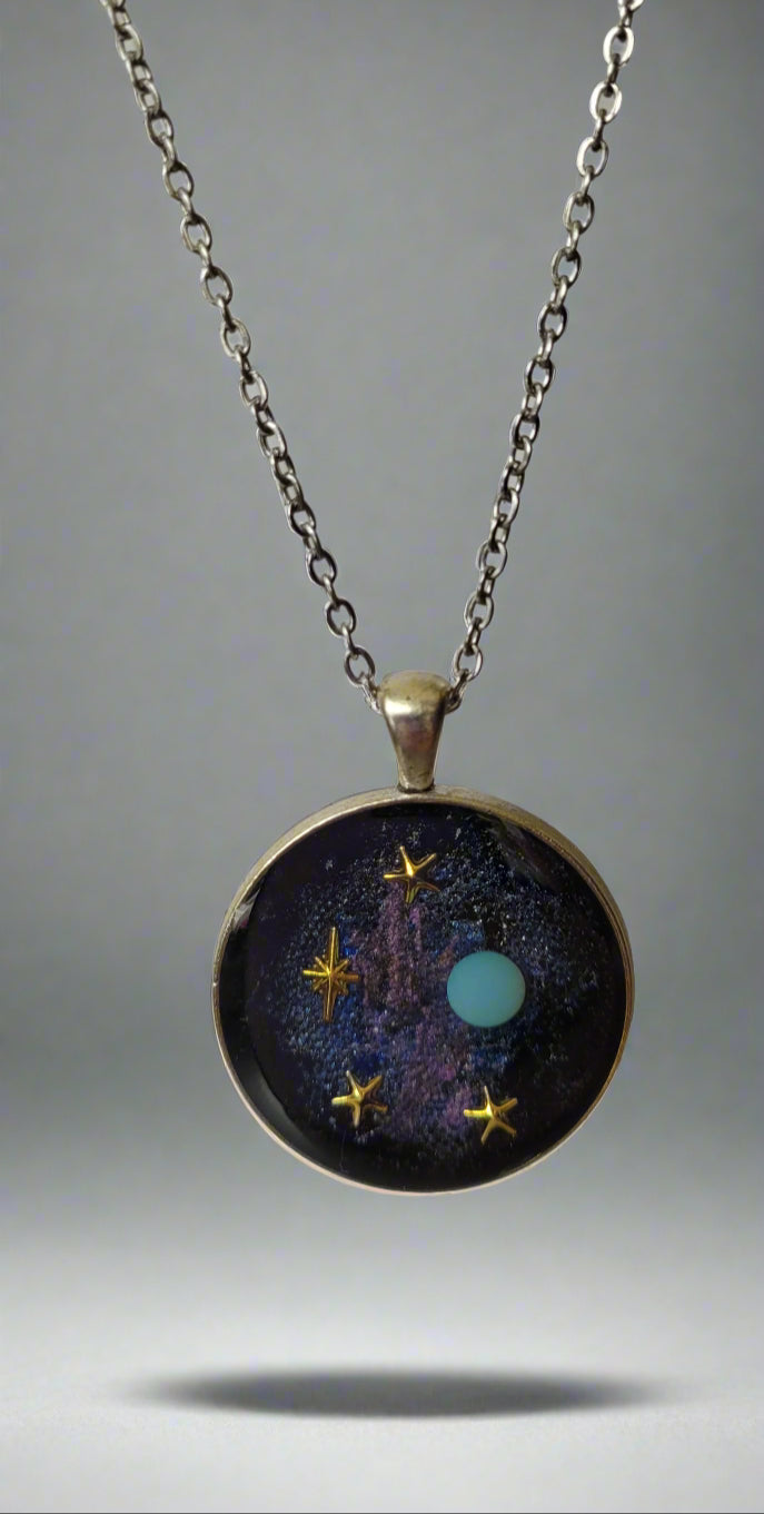 Necklace with a pendant featuring a cosmic design on a light gray background