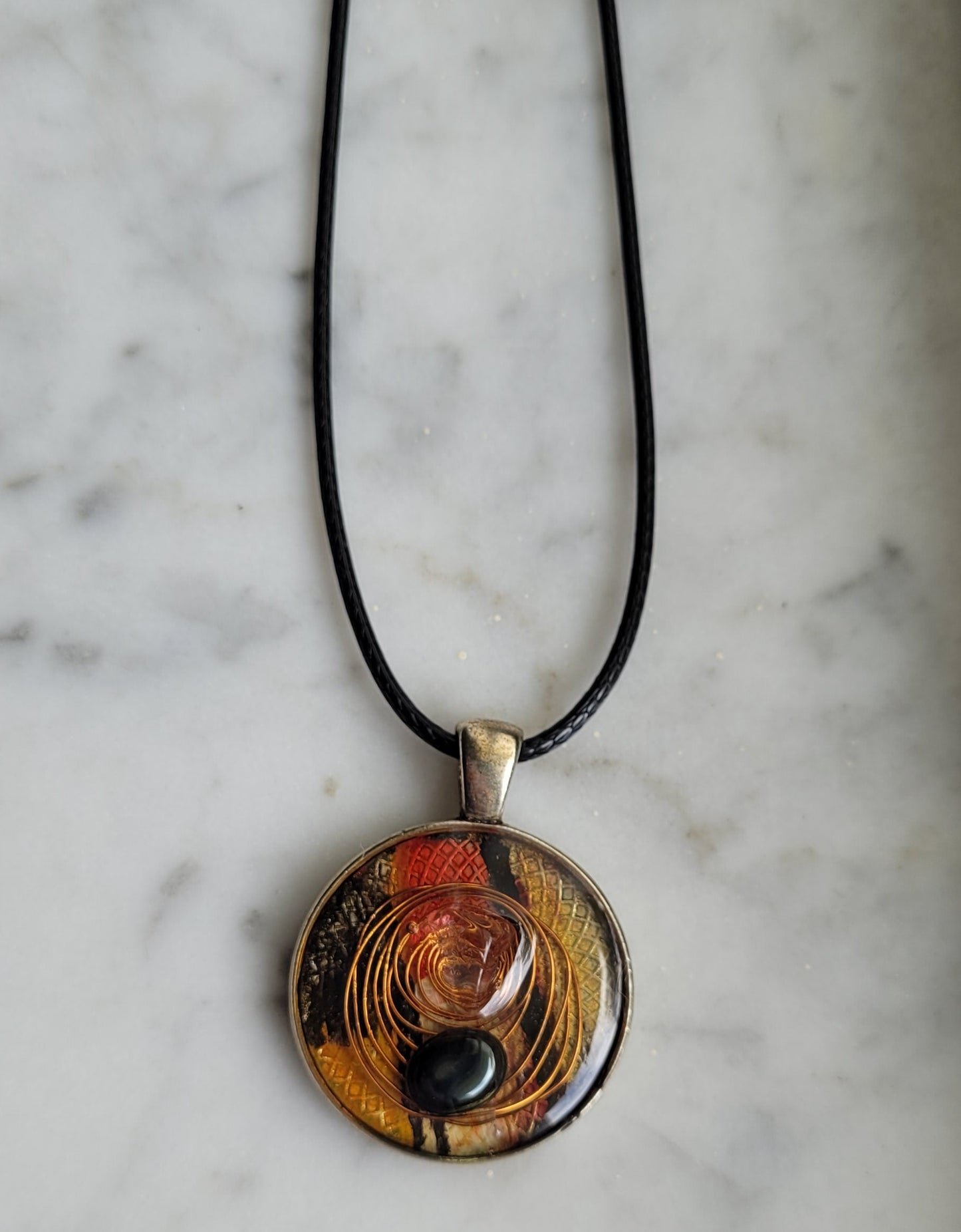 Necklace with a round pendant on a marble surface