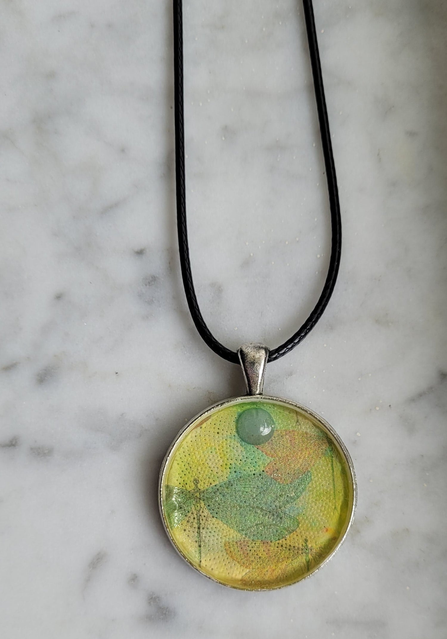 Necklace with a round pendant on a marble surface