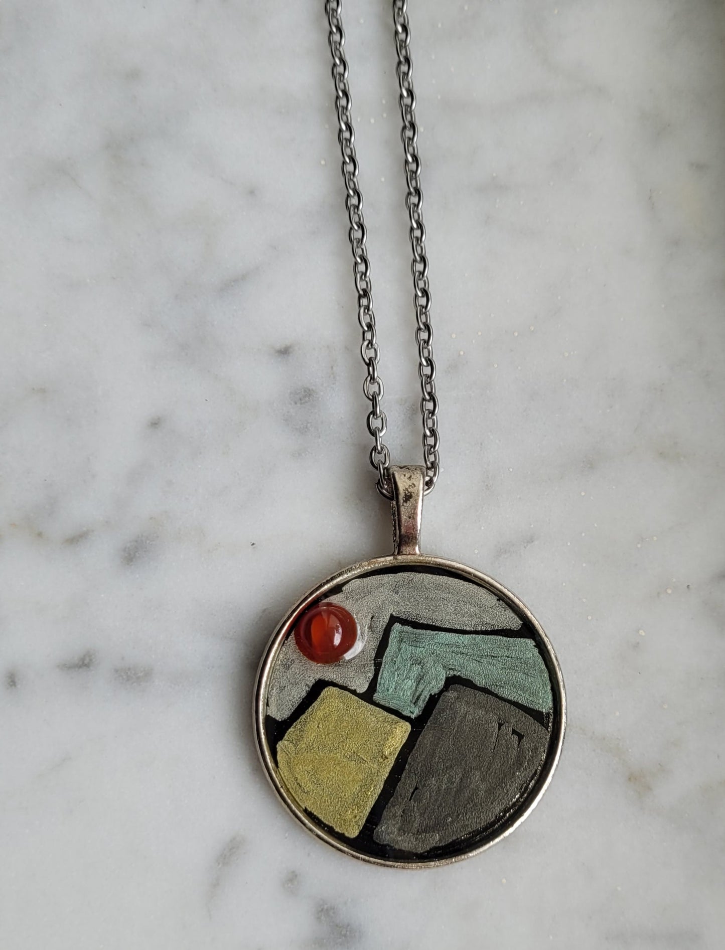 Necklace with a circular pendant on a marble surface