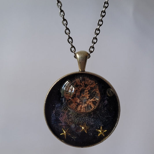 Necklace with a round pendant featuring celestial design on a light gray background